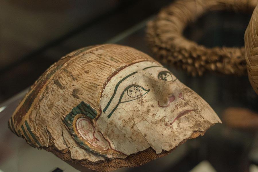 połamana maska sarkofagu mumii leży na szklanej witrynie