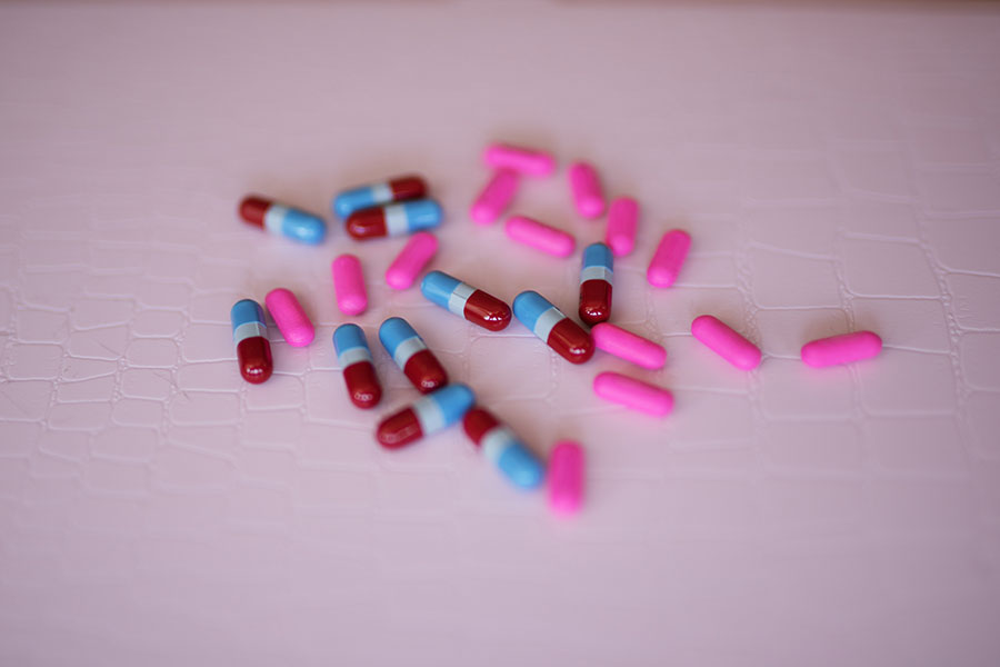 tabletki kolorowe narkotyki leżą na stole