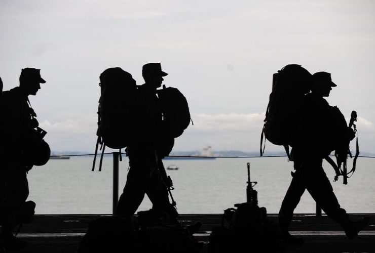 żołnierze w moro z plecakami idą