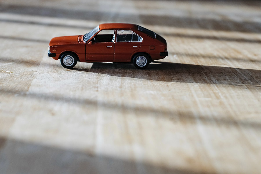 Model małego czerwonego samochodu na podłodze