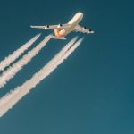 Biały samolot pasażerski leci w niebieskim niebie