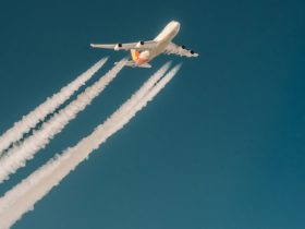 Biały samolot pasażerski leci w niebieskim niebie