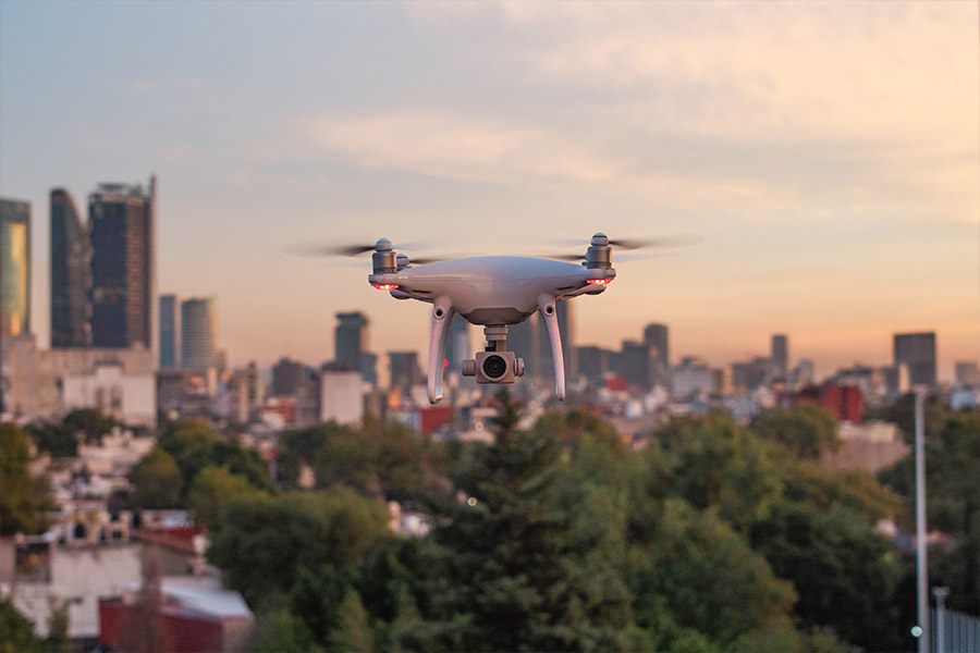 Biały dron z kamerą leci nad miastem