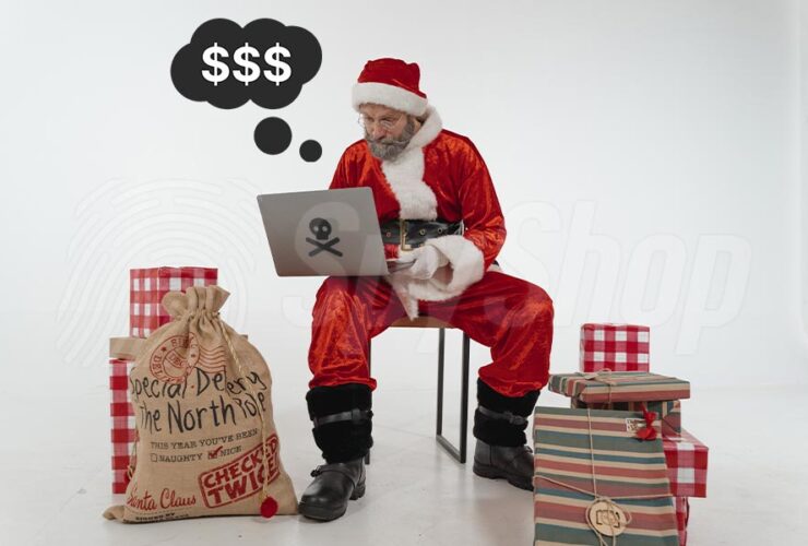 Haker Mikołaj siedzi przy laptopie obok prezenty w workach