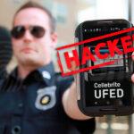 Policjant w mundurze trzyma telefon z opragramowanie UFED