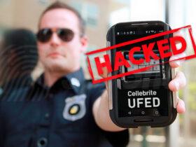 Policjant w mundurze trzyma telefon z opragramowanie UFED