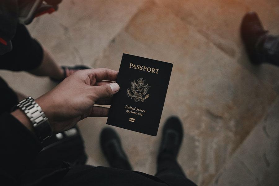 mężczyzna trzyma czarny paszport w ręce na lotnisku