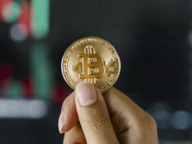 złota moneta bitcoin w rękach osoby