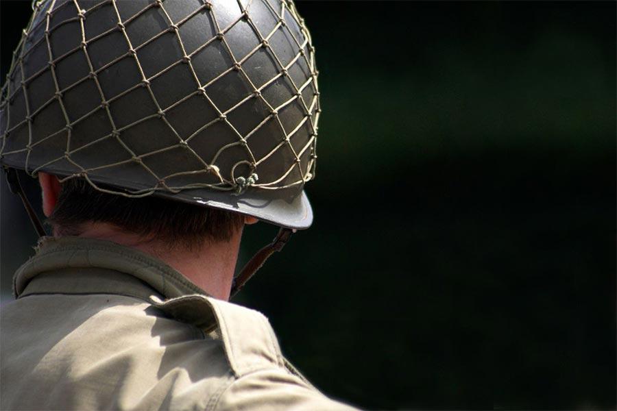 żołnierz stoi w wojennym kasku z siatką