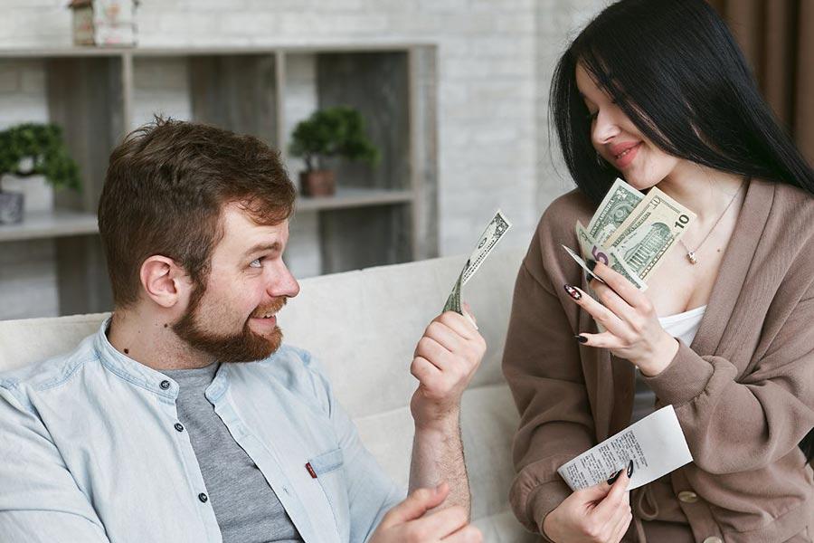 mężczyzna podaje gotówkę kobiecie która trzyma walutę