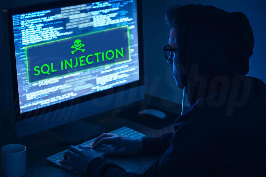 haker siedzi w ciemnym pokoju pzy komputerze z wyświetlonym sql injection