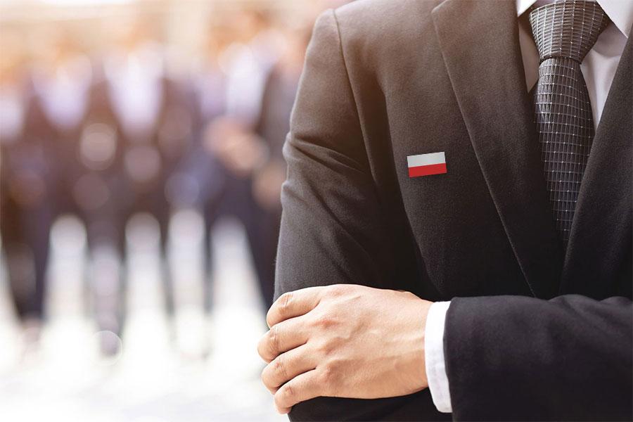 Mężczyzna w garniturze z polską flagą