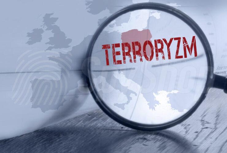 lupa nad mapą świata z napisem terroryzm i polską