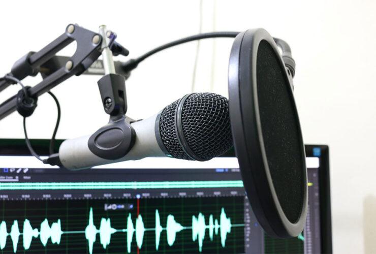 mikrofon obok komputera z włączonym programem do odszumiania nagrań audio