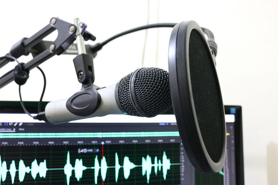 mikrofon obok komputera z włączonym programem do odszumiania nagrań audio