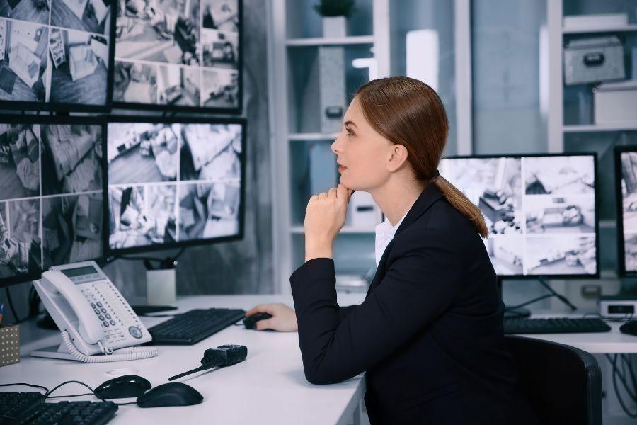 pracodawca siedzi przed monitorami i monitoruje komputer pracownika