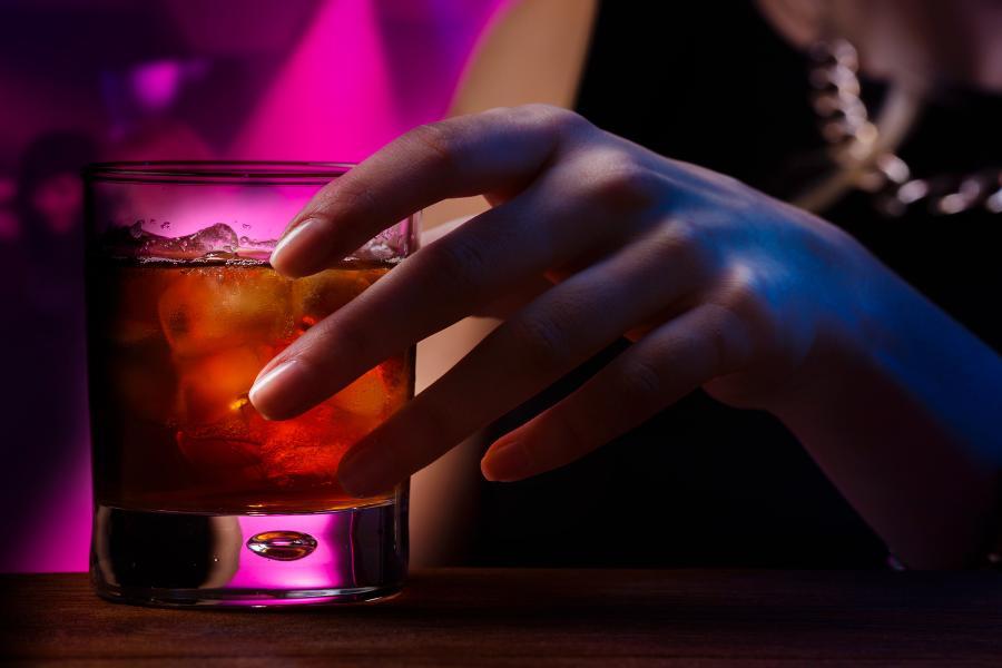 ręka kobiety w klubie trzyma drinka