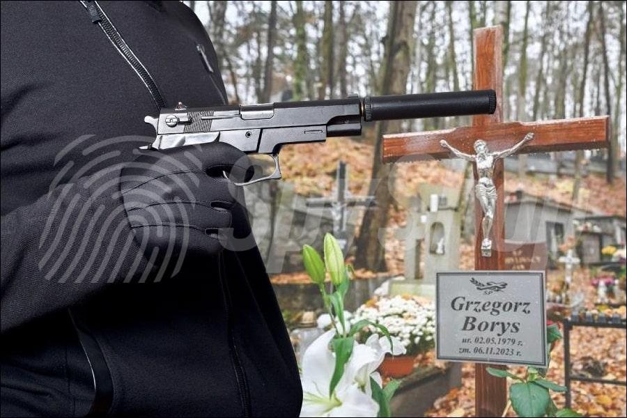 Po prawej stronie zdjęcie krzyża z grobu Grzegorza Borysa. Po lewej stronie sylwetka osoby, która trzyma broń z tłumikiem.