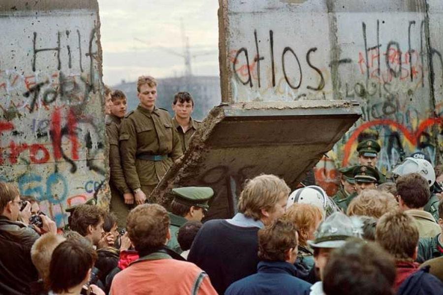 Historyczne zdjęcie przedstawiające przerwanie muru berlińskiego.