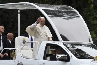 Papież Franciszek macha do wiernych w papamobile